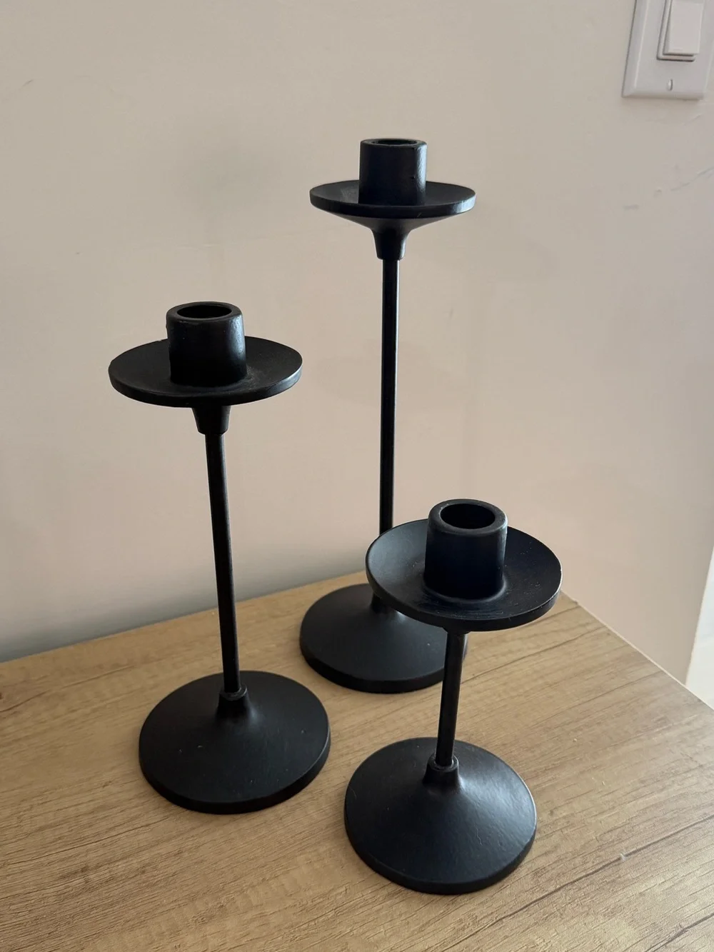 Set of three black metal taper candle holders
